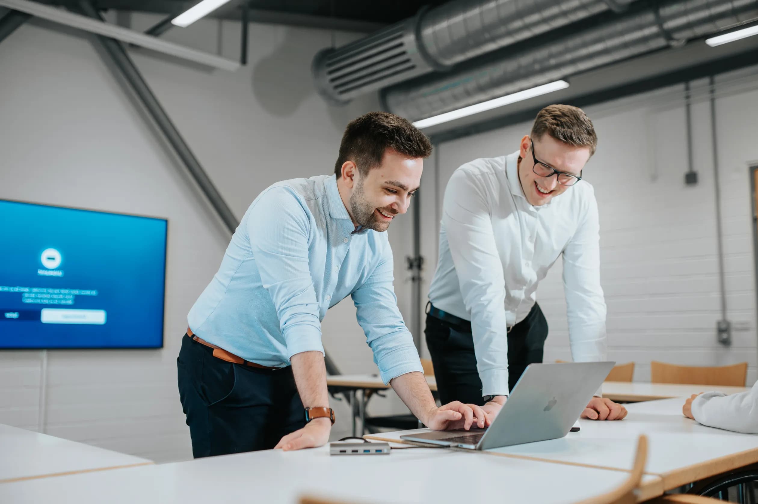 Working atmosphere at northcommit: IT consultants work on a software solution while looking at a MacBook.